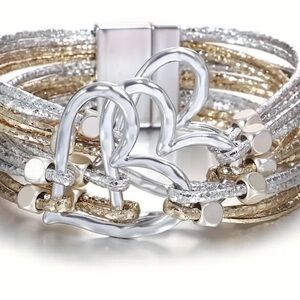 New, Multi Strand 3 heart Bracelet. Silver-tone hearts & strap is gold & silver.